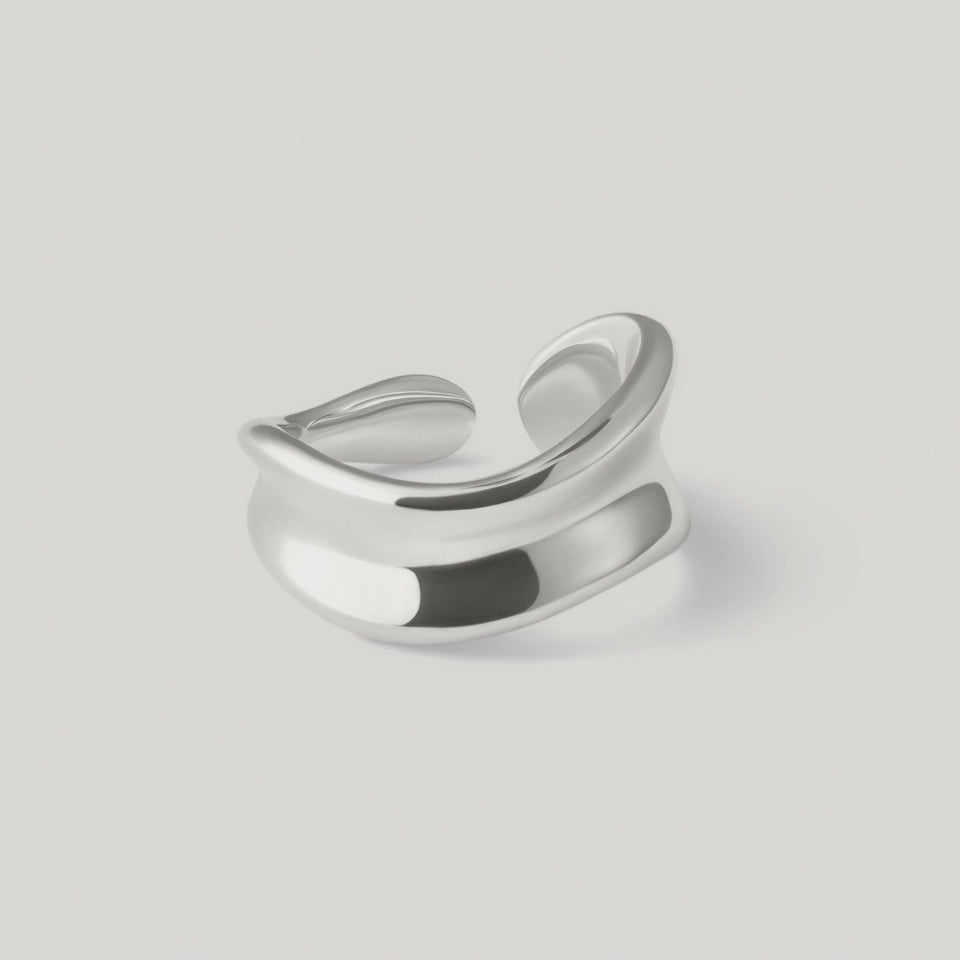 rotating video of a sterling silver, asymmetrical, open-ended ring with a smooth, polished surface.