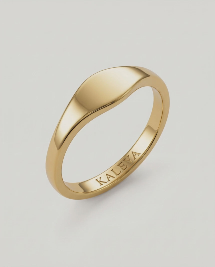 360 video of a  gold signet ring with a smooth, curved surface on a white background.