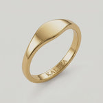 360 video of a  gold signet ring with a smooth, curved surface on a white background.