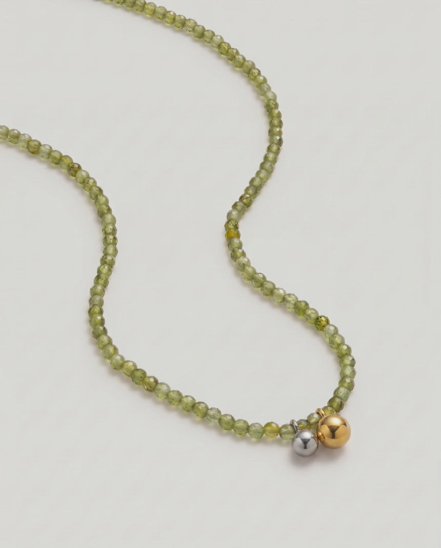 video of an Olive green beaded necklace in gold, with green cubic zirconia beads and a two-tone pendant 