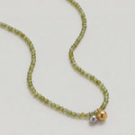 video of an Olive green beaded necklace in gold, with green cubic zirconia beads and a two-tone pendant 