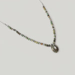 video of a necklace with variegated African turquoise beads and silver spacers, ending in a teardrop-shaped pendant