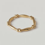 rotating video of a gold-plated ring with heart-shaped links and elongated bars creating a chain-like design
