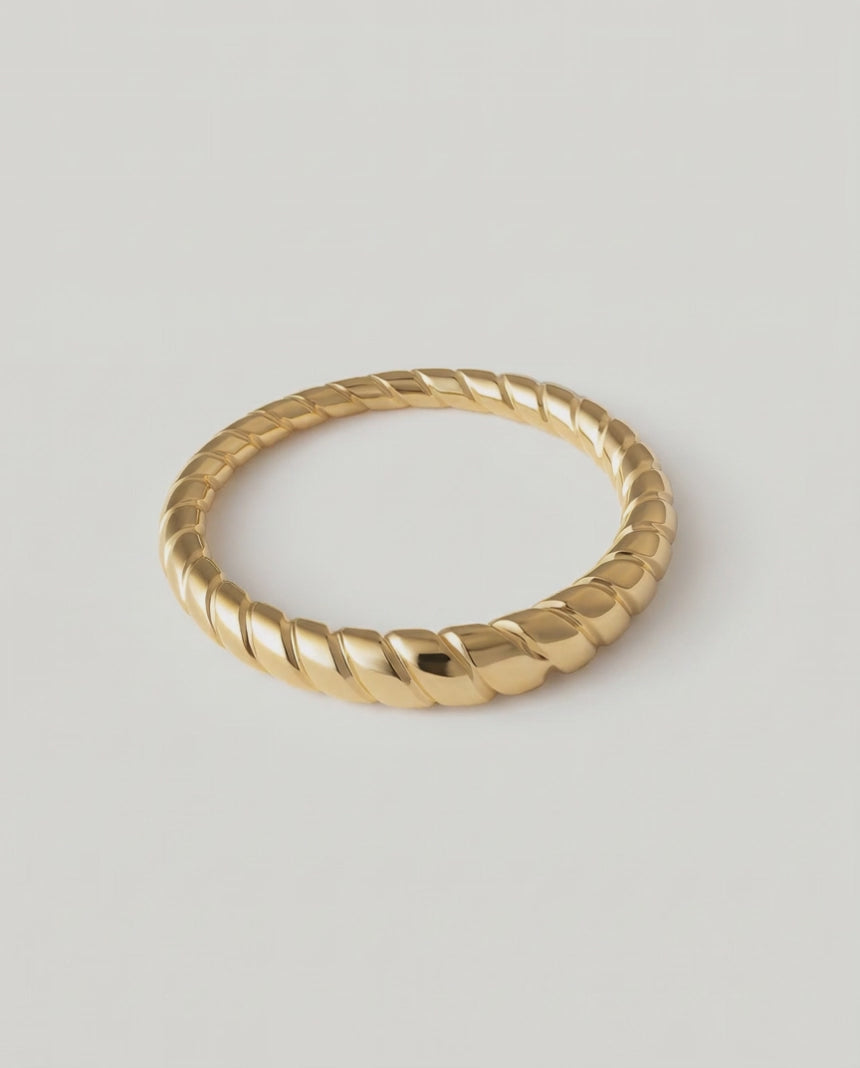 360 video of a gold-plated metal ring with a twisted rope design, displayed against a white background.