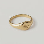 a video showing a gold signet ring with a star engraving on the top, crafted from gold-plated metal.