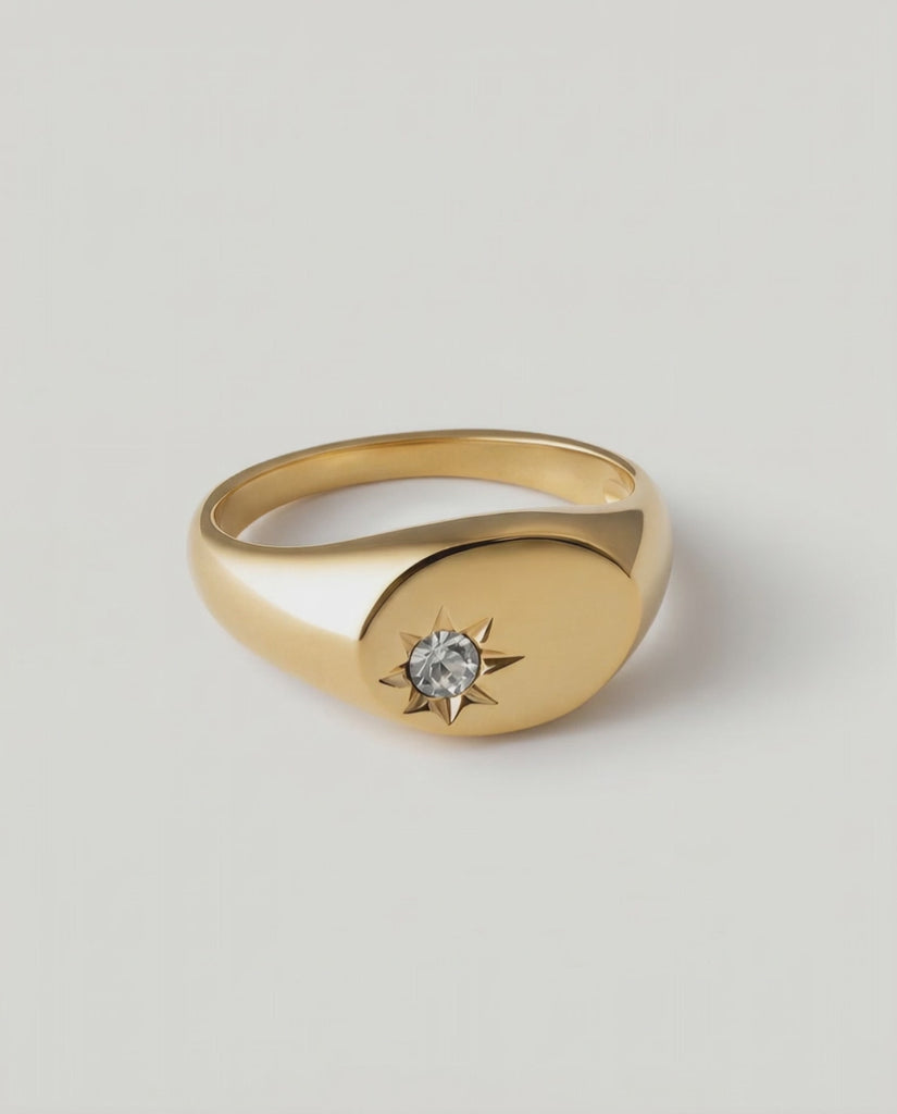rotating video of a gold-plated signet ring with an oval face featuring a dazzling stone set in a starburst pattern