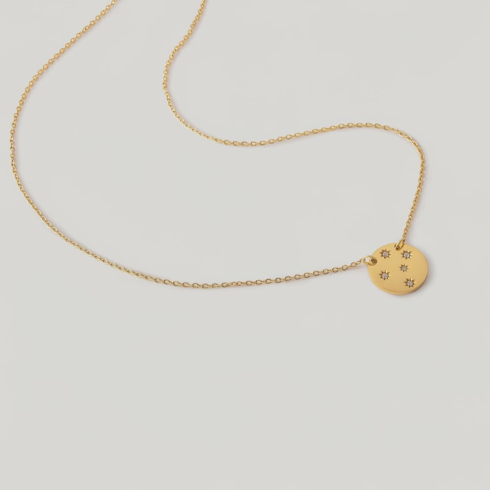video of a gold-plated necklace with a round medallion pendant
