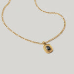 video of an 18k gold-plated stainless steel necklace with a polished Figaro chain and an oval medallion pendant featuring a deep black onyx stone