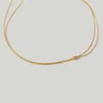 video of a gold-plated choker necklace with a simple infinity symbol design