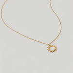 video of a gold necklace with a minimalist sun charm pendant