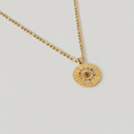 video showing A gold-plated curb chain necklace with a round zodiac wheel pendant featuring multicolored sparkling crystals and a central moonstone.