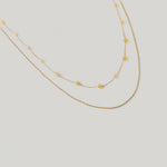 video of a two-tone necklace with gold links and yellow stones