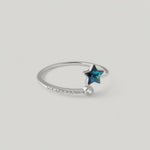 video showing a sterling silver ring with a blue topaz star in the center, surrounded by smaller sparkling gemstones on the band
