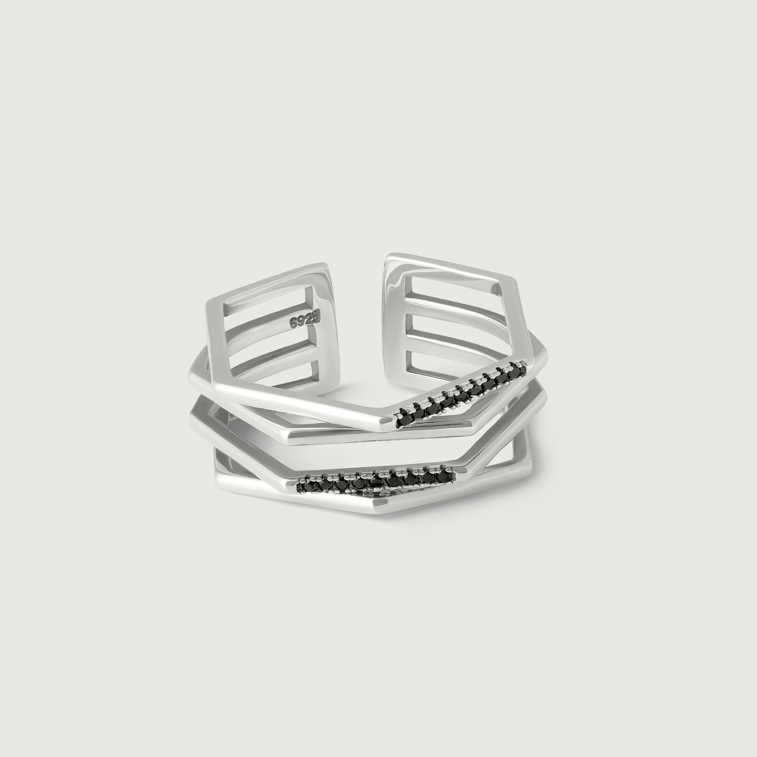 A silver ring with a hexagonal design featuring geometric flowing lines and black crystal accents on the edges.
