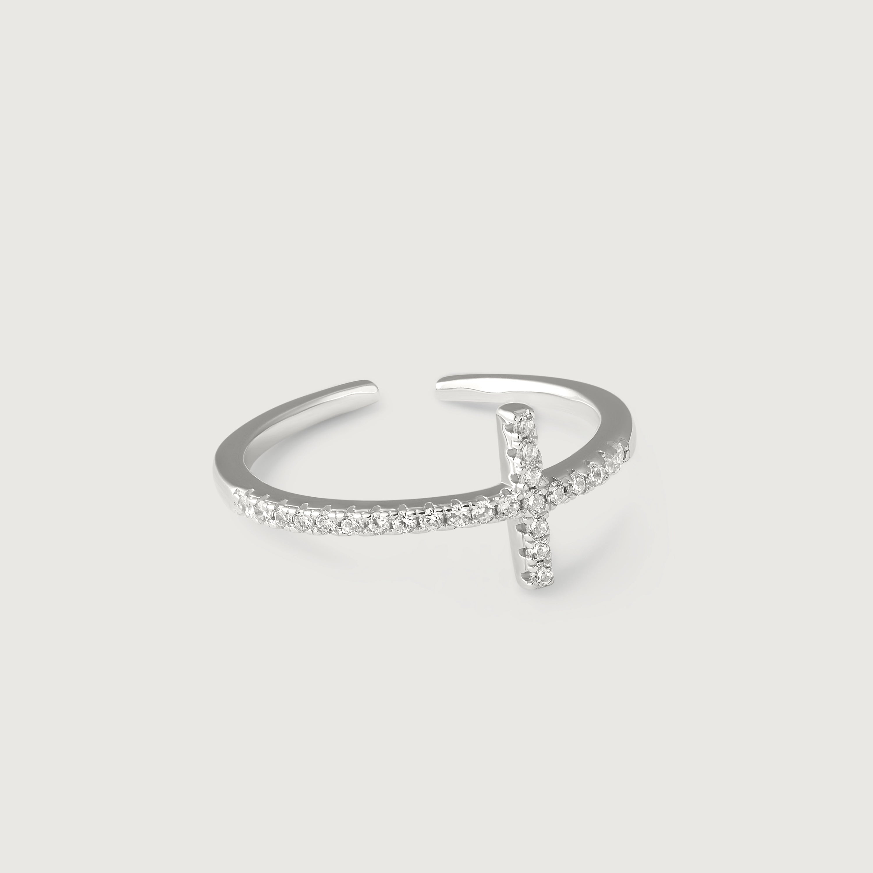 A silver ring with a delicate cross adorned with sparkling diamonds on the top, set on a slender band with pave-set diamonds.
