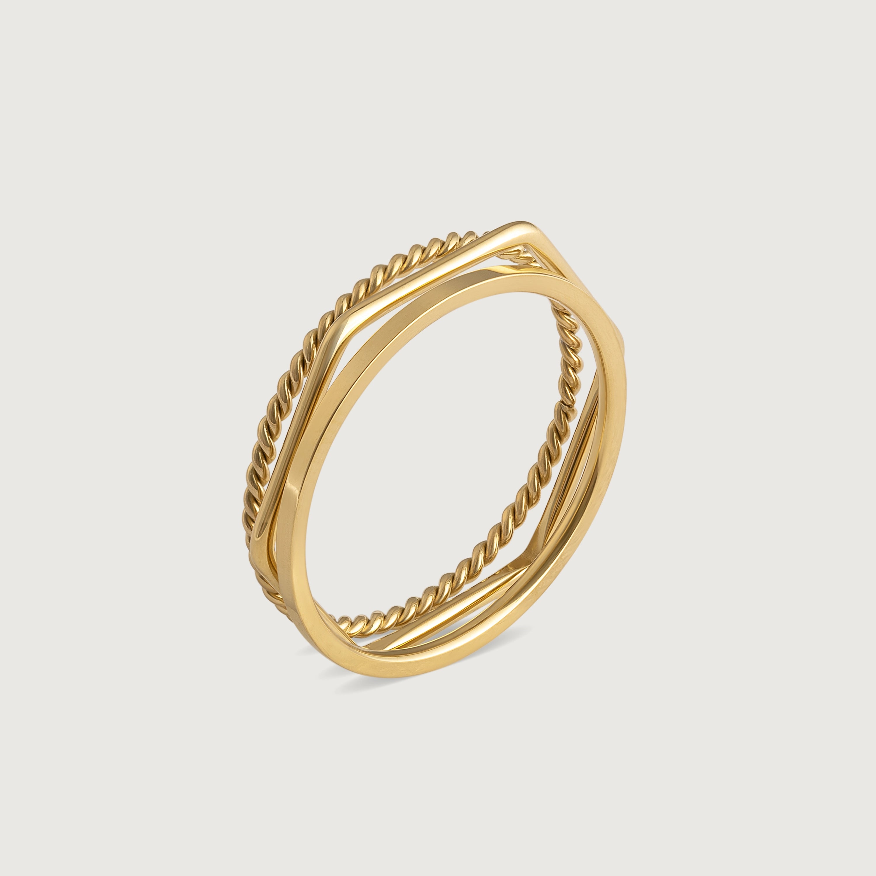 Three gold-plated stainless steel stacking rings with a twisted design, polished finish