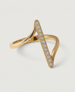 A contemporary gold-plated ring with an asymmetric design featuring a sleek bar adorned with a line of sparkling stones, presented against a white background.