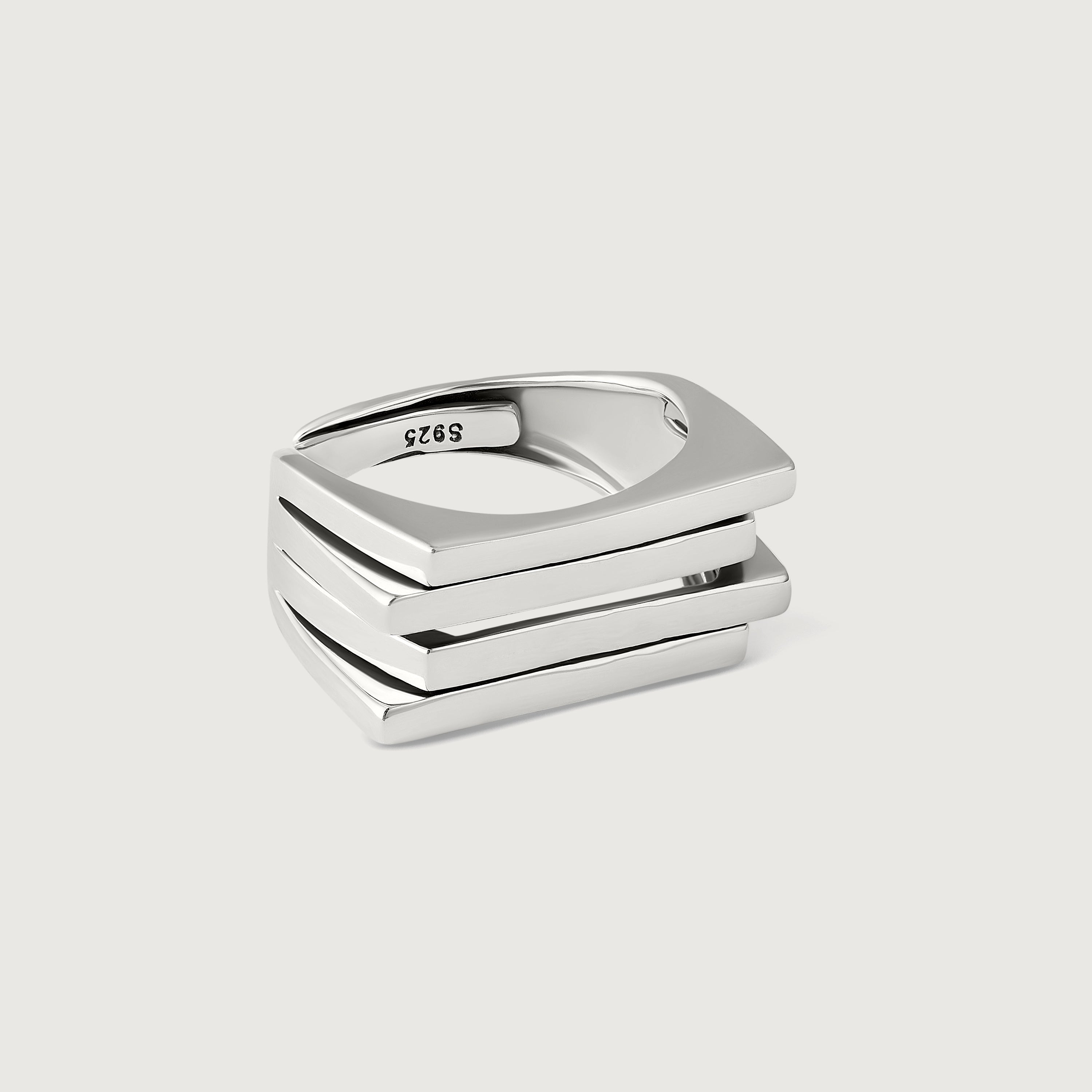 A silver ring with a bold, architectural design consisting of layered silver plates.