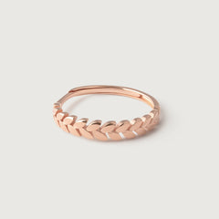 A rose gold ring with a band designed from intertwined leaves, symbolizing victory and honor.
