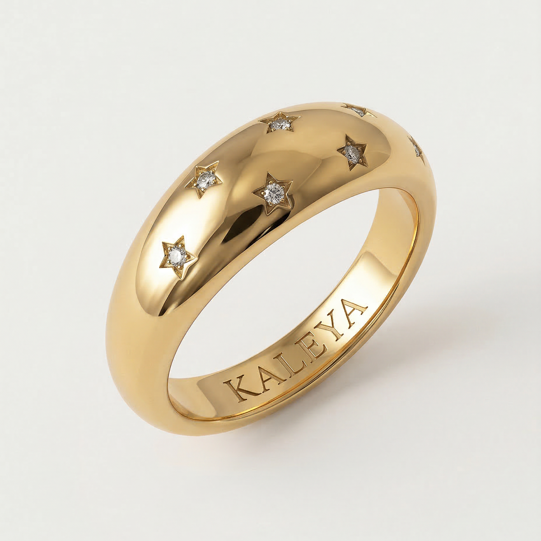 A gold-plated ring with a smooth, domed surface adorned with five star-shaped bezels containing crystals.