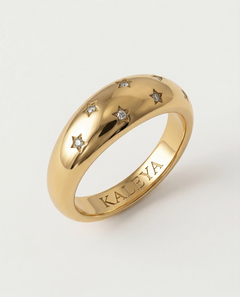 A gold-plated ring with a smooth, domed surface adorned with five star-shaped bezels containing crystals.