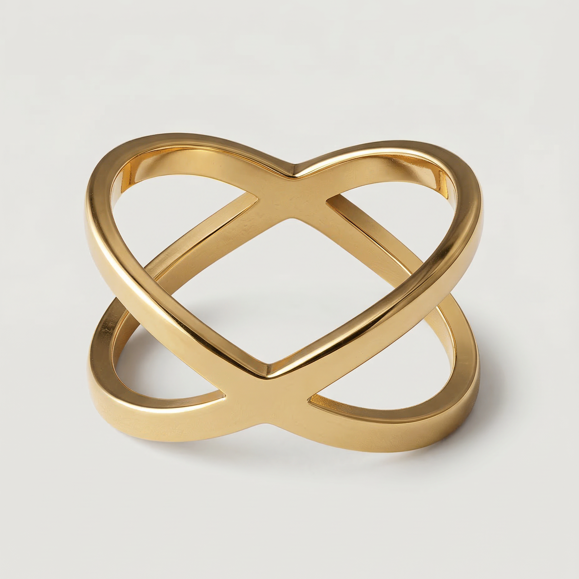 A gold-plated ring with two slender bands that intersect creating a modern X-shape design.